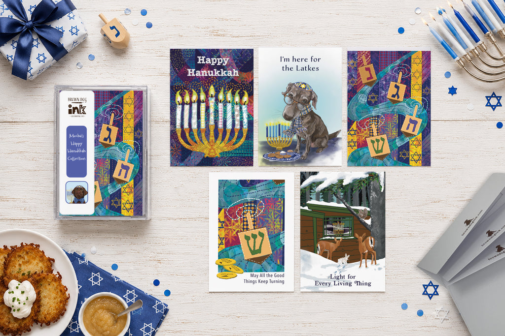 Mocha’s Happy Hanukkah five-card collection featuring original illustrated menorah, dreidel, latke, dog and winter wildlife designs by Susan J. York, shown with the Brown Dog Ink card box.