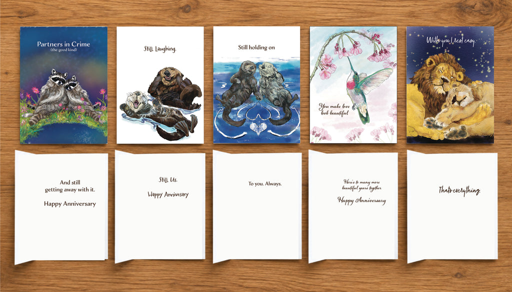 Love Notes & Anniversary greeting card collection showing the fronts and interior messages of five original illustrated cards by Susan J. York, featuring raccoons, otters, hummingbird and lions.