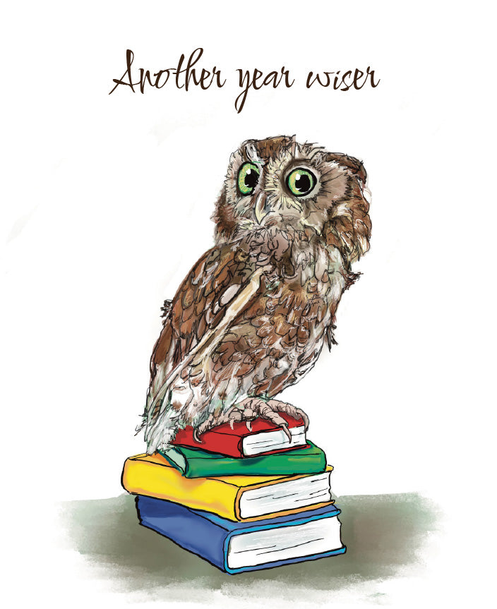 A whimsical illustration of a brown owl with large green eyes perched on a stack of colorful books, with the phrase 'Another year wiser' written above in brown script on a white background. Original artwork by Susan J. York.