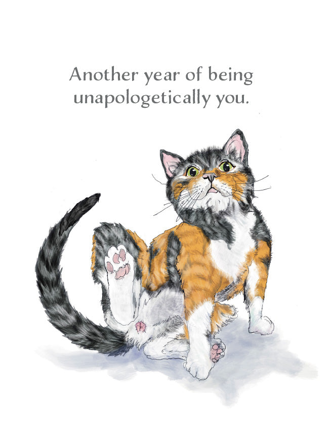 A watercolor-style illustration of a calico cat sitting on a white background with the text above reading, 'Another year of being unapologetically you.'. Original artwork by Susan J. York.